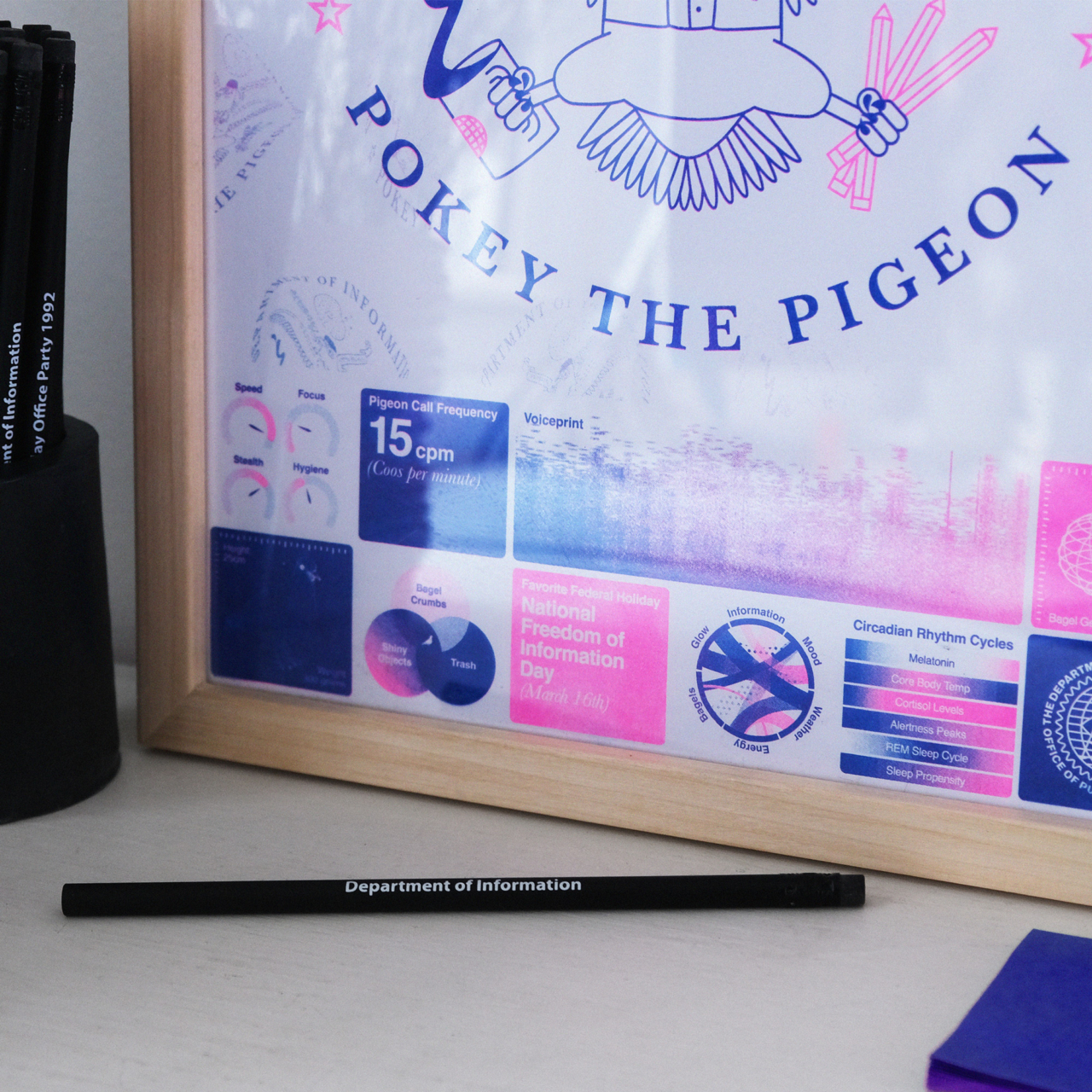a close up photo of a pink and blue risograph poster framed and sitting on a desk