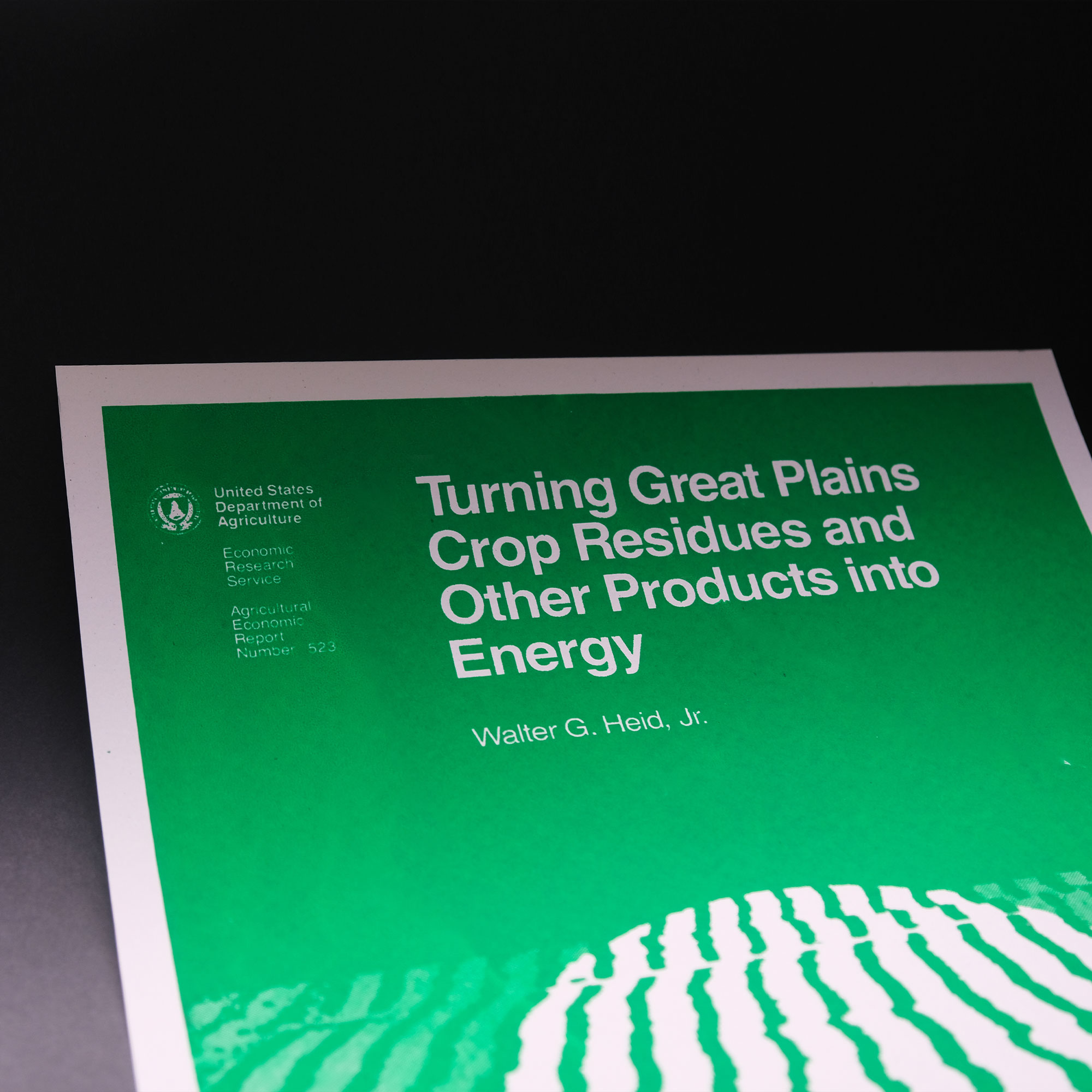 A bright green and white poster of the 1984 usda report cover for Turning Great Plains Crop Residues and Other Products into Energy